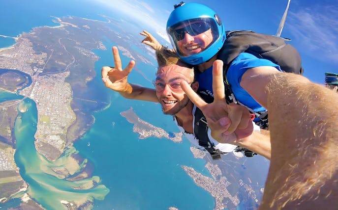 Tandem skydiving over Newcastle, Australia with ocean and city views.