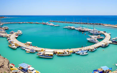 Santorini harbor with catamarans docked for luxury cruise tours.