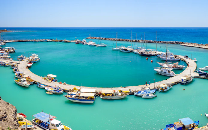 Santorini harbor with catamarans docked for luxury cruise tours.
