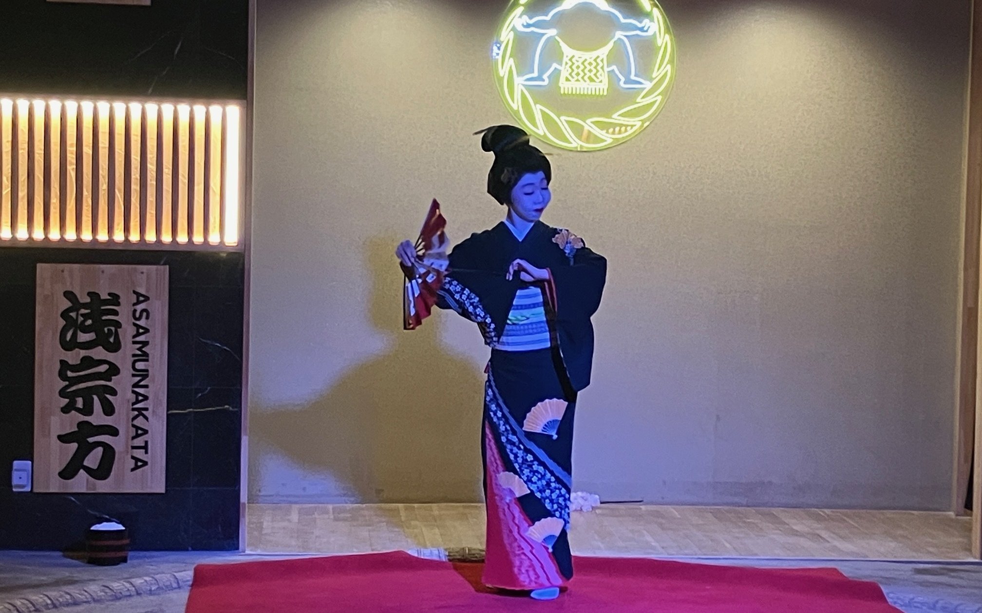 Geisha performing traditional dance at sumo show in Japan.