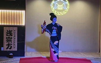 Geisha performing traditional dance at sumo show in Japan.