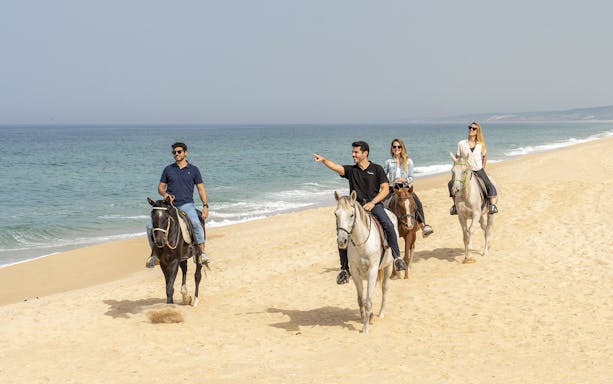 Horseback riders on Comporta beach during Lisbon to Setúbal city tour.