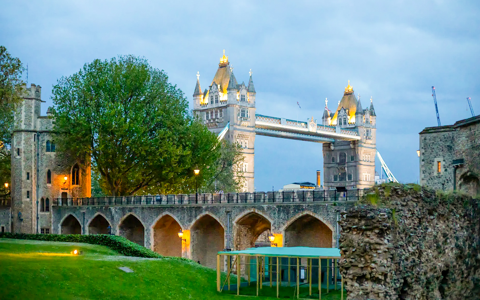 Tower of London with illuminated Tower Bridge at dusk during VIP after-hours tour.