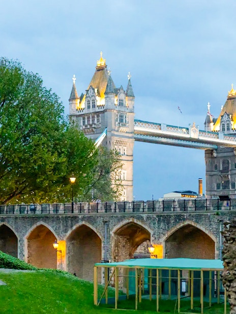 Tower of London with illuminated Tower Bridge at dusk during VIP after-hours tour.