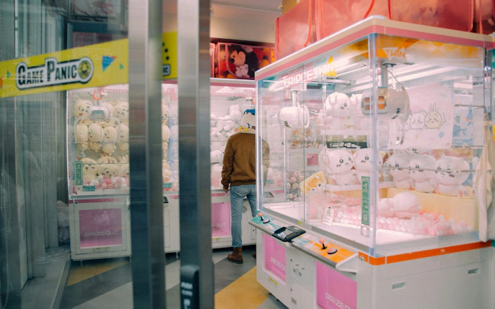 Arcade claw machines in Akihabara, Tokyo, featuring plush toys during an anime and gaming tour.