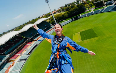 Adelaide Oval roof climb participant smiling with stadium view.