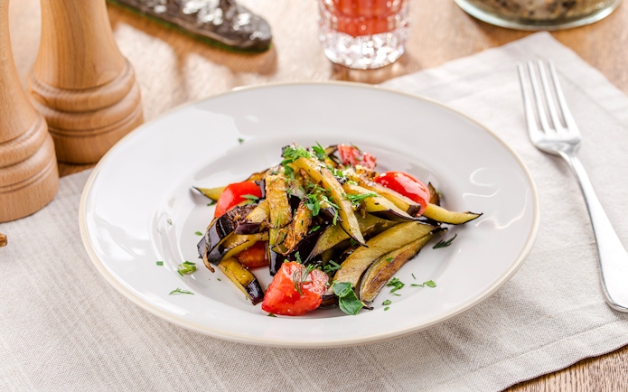 Grilled vegetables with herbs on a white plate for lunch.