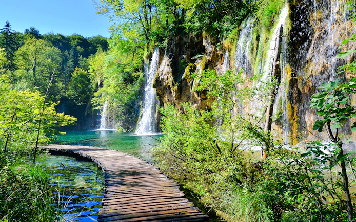 Boardwalk winding through waterfalls at Plitvice Lakes National Park, Croatia.