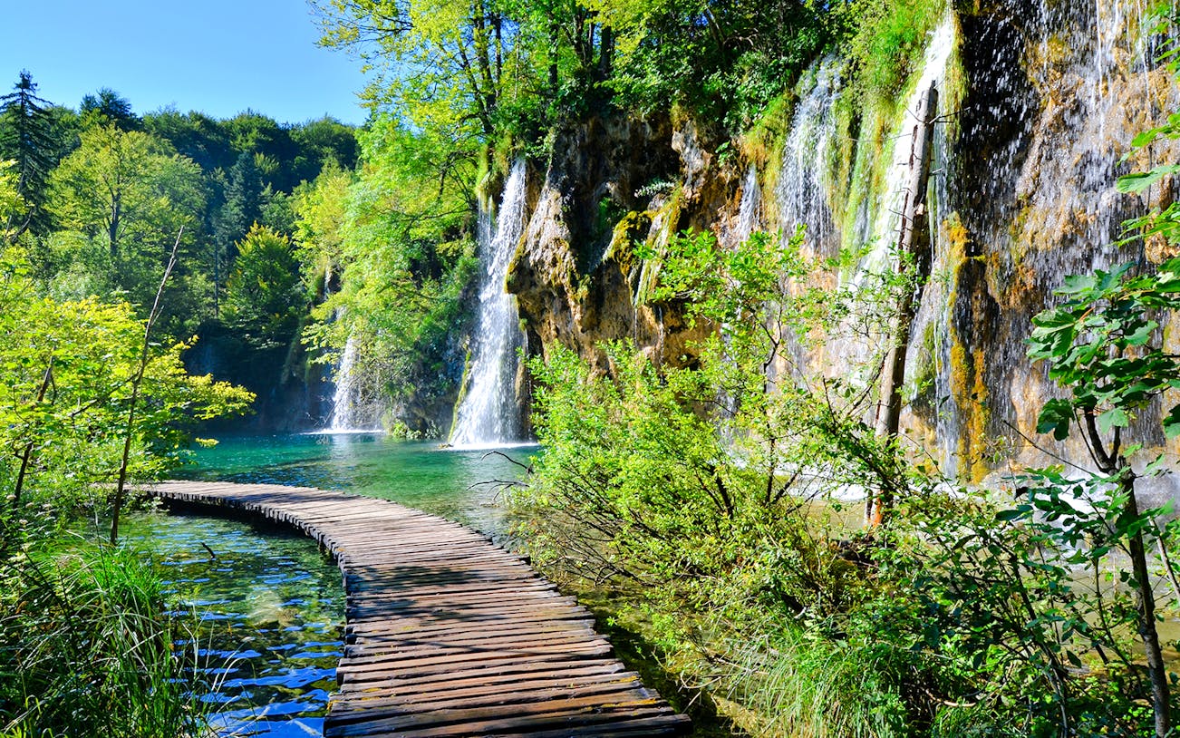 Boardwalk winding through waterfalls at Plitvice Lakes National Park, Croatia.
