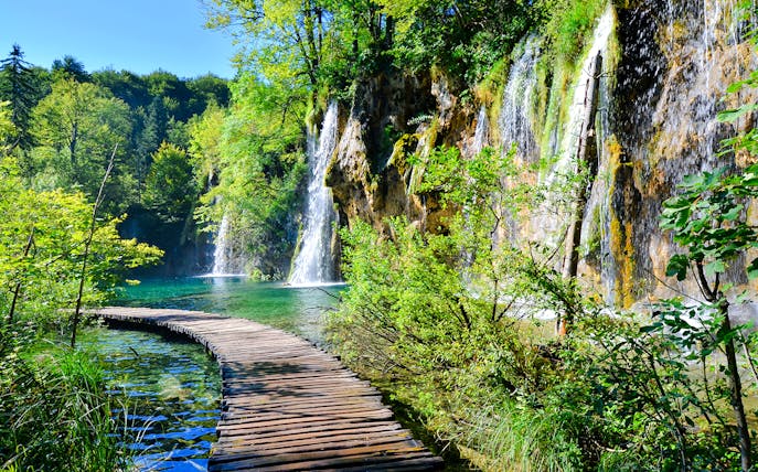 Boardwalk winding through waterfalls at Plitvice Lakes National Park, Croatia.