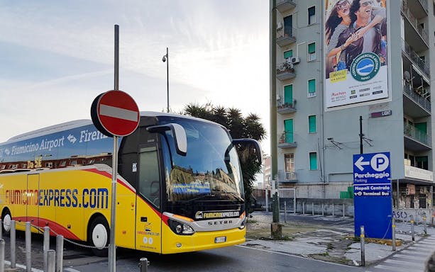 Fiumicino Express bus parked near Naples Centrale sign.