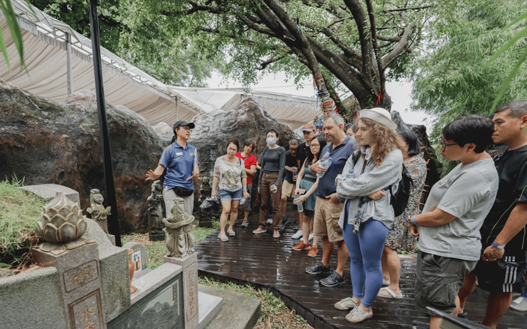 Tour group listens to guide by historic tombstone at Hell's Museum.