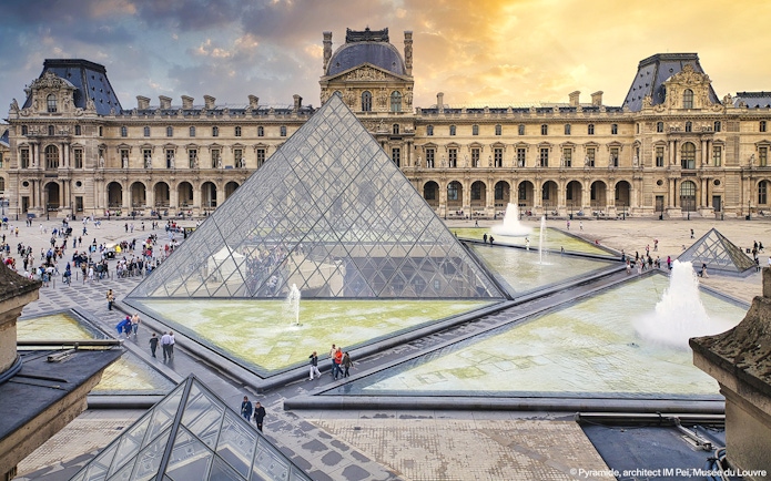 Louvre Museum courtyard with glass pyramid and fountains, Paris, France.