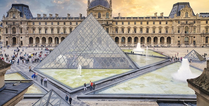 Louvre Museum courtyard with glass pyramid and fountains, Paris, France.