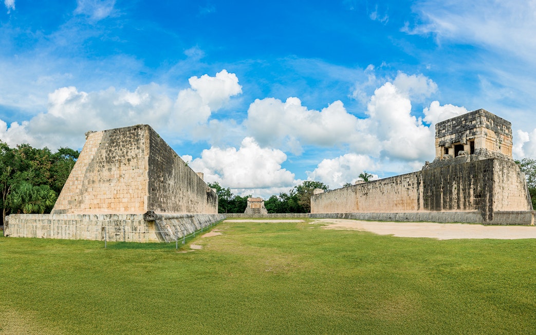 Mayan Ball Game Field at Chichen Itza with ancient stone walls and grassy court.