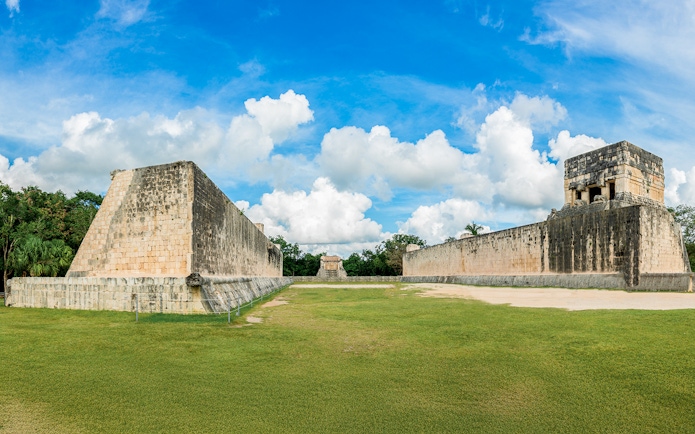 Mayan Ball Game Field at Chichen Itza with ancient stone walls and grassy court.