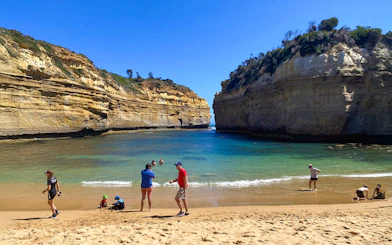 Visitors enjoying Loch Ard Gorge beach on the Great Ocean Road Day Tour.