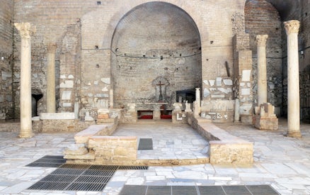 Catacombs of Domitilla interior with ancient columns and altar, Rome guided tour.