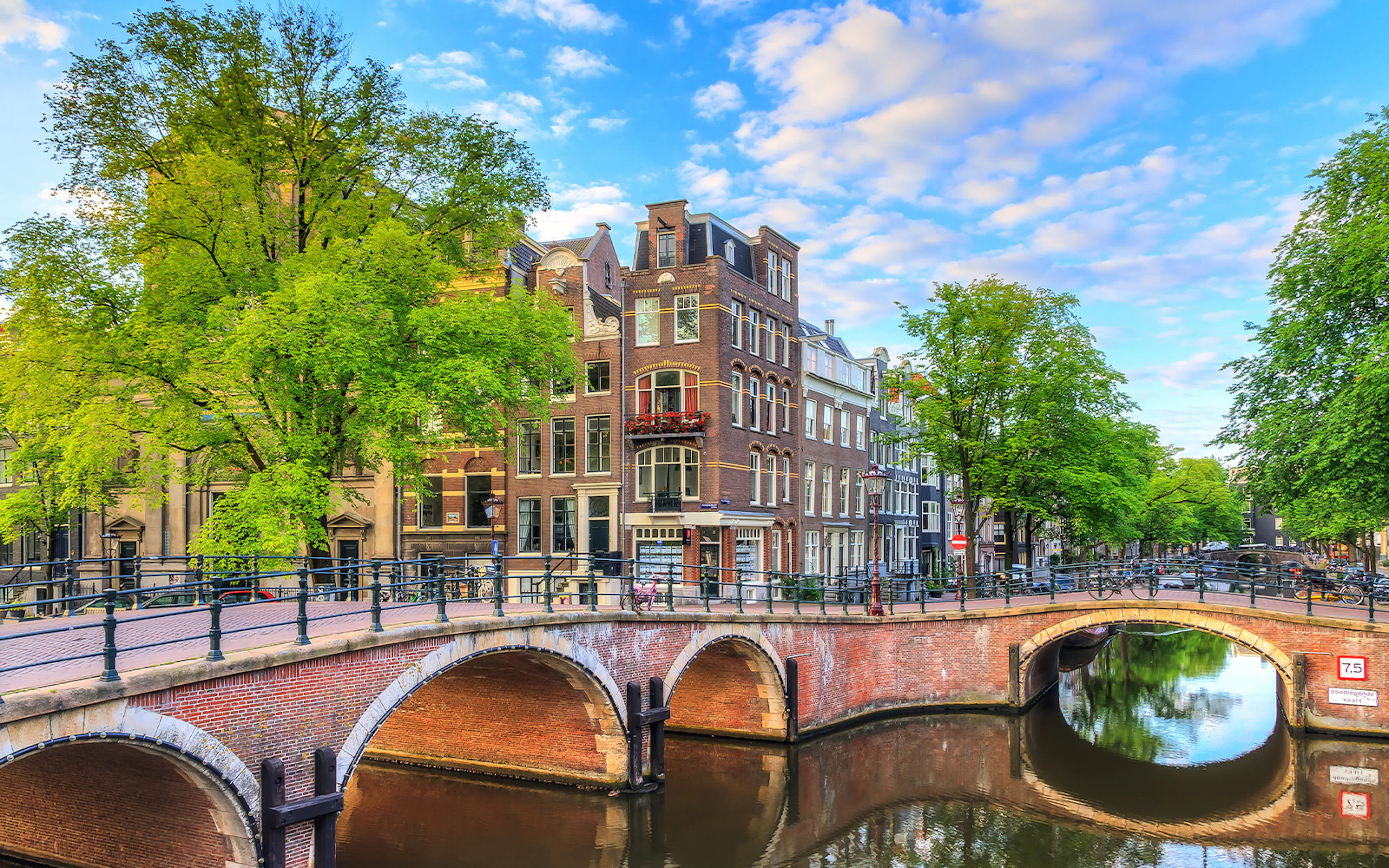 Reguliersgracht canal with arched bridge and historic buildings in Amsterdam.