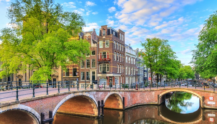 Reguliersgracht canal with arched bridge and historic buildings in Amsterdam.