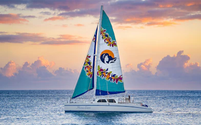 Catamaran sailing at sunset in Waikiki for a night fireworks tour.