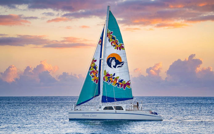 Catamaran sailing at sunset in Waikiki for a night fireworks tour.