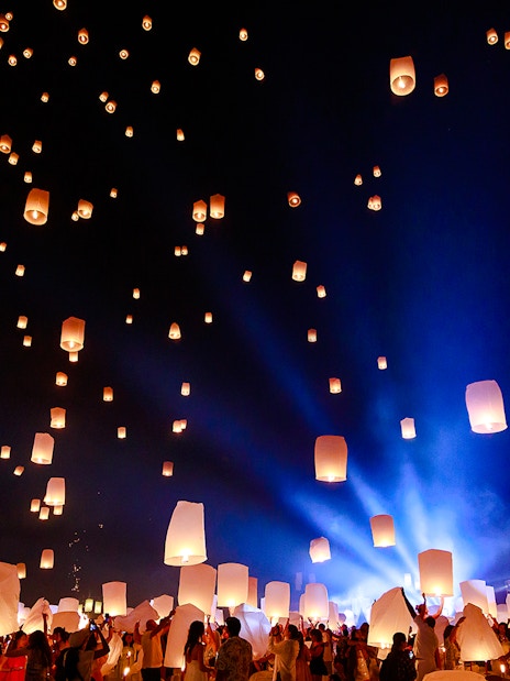 People releasing lanterns into the night sky at Chiang Mai Sky Lanterns Festival 2025.
