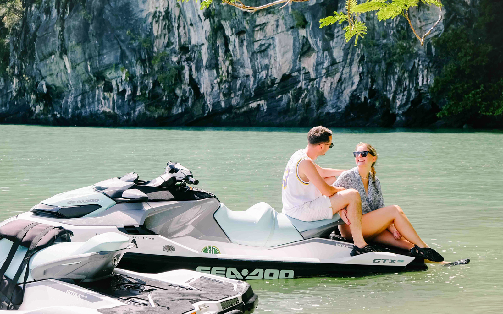 Jet ski on water with two people at Langkawi's UNESCO Kilim Geopark.