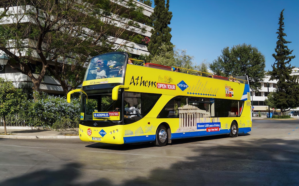 Athens open-top tour bus on city street, part of Turbopass Athens City Pass.