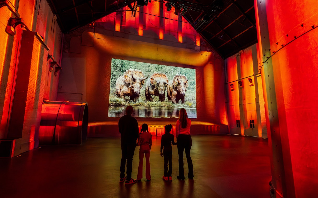 Visitors viewing dinosaur exhibit at Prehistoric Planet: Dinosaurs – The Immersive Experience.