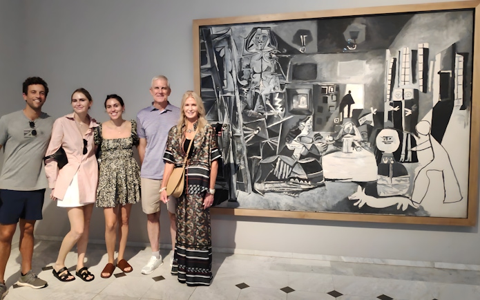 Tourists with guide at Picasso Museum viewing a black and white painting.