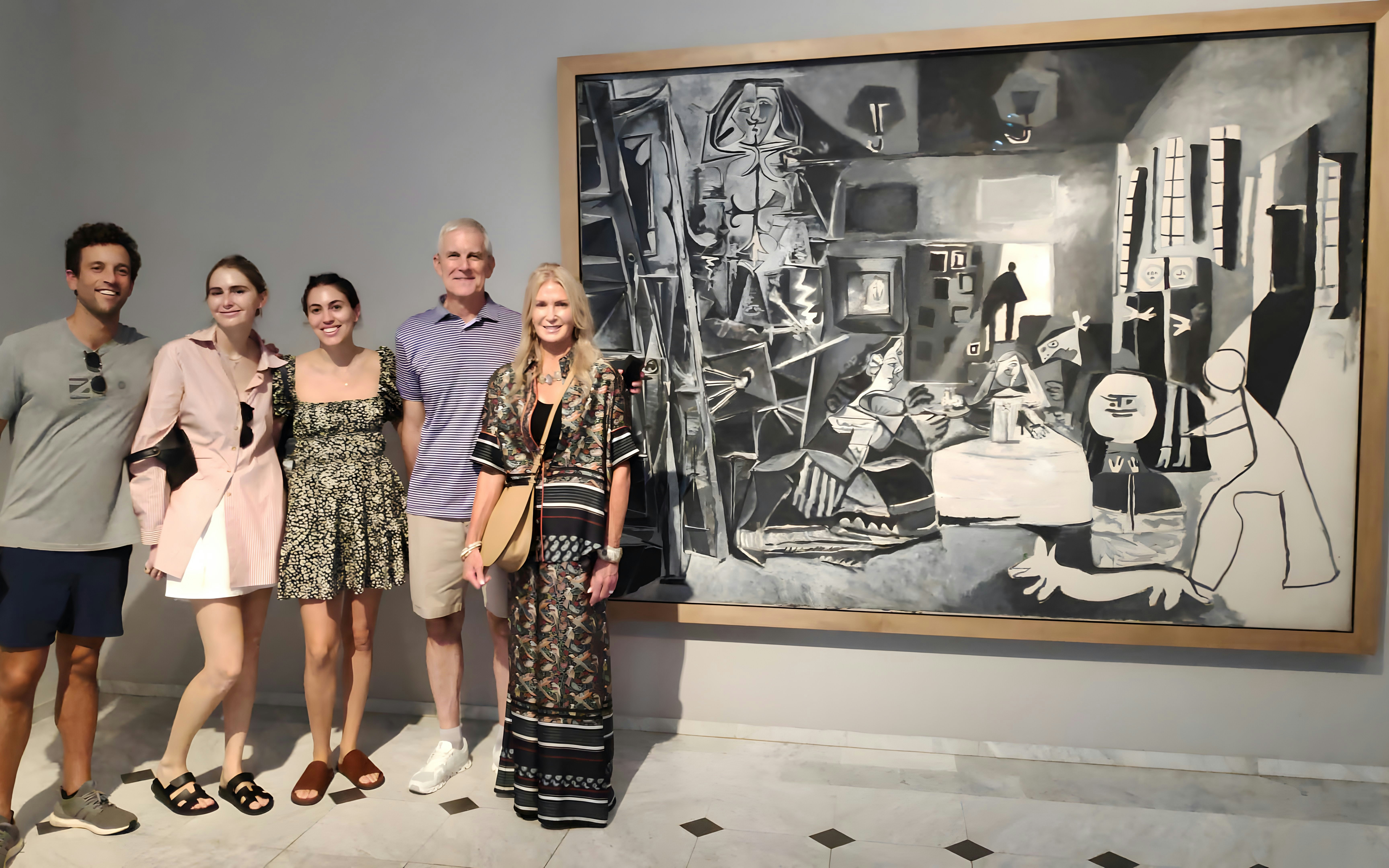 Tourists with guide at Picasso Museum viewing a black and white painting.