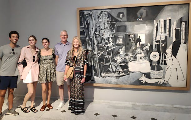 Tourists with guide at Picasso Museum viewing a black and white painting.