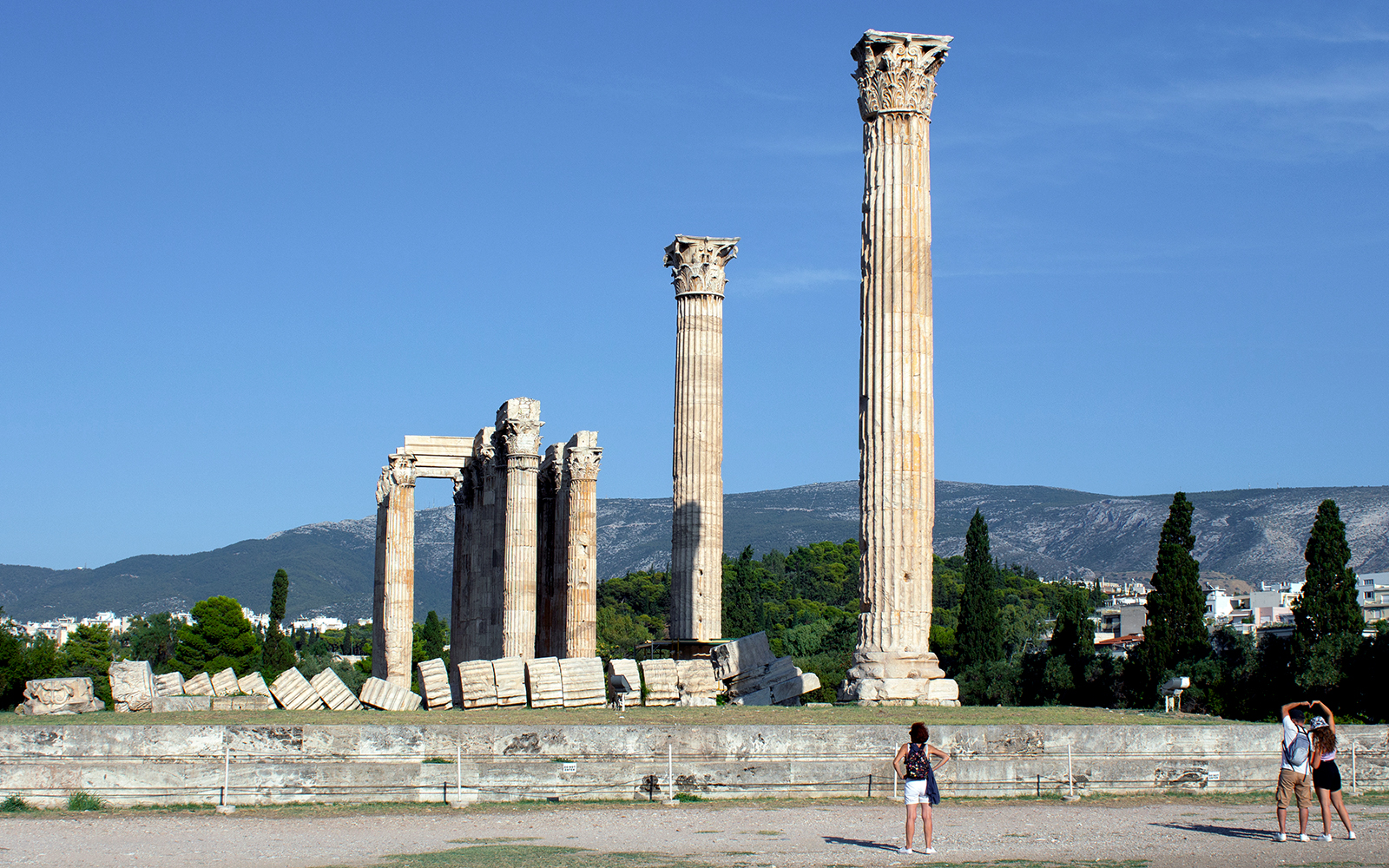 Ancient Temple of Olympian Zeus ruins in Athens with tourists exploring.