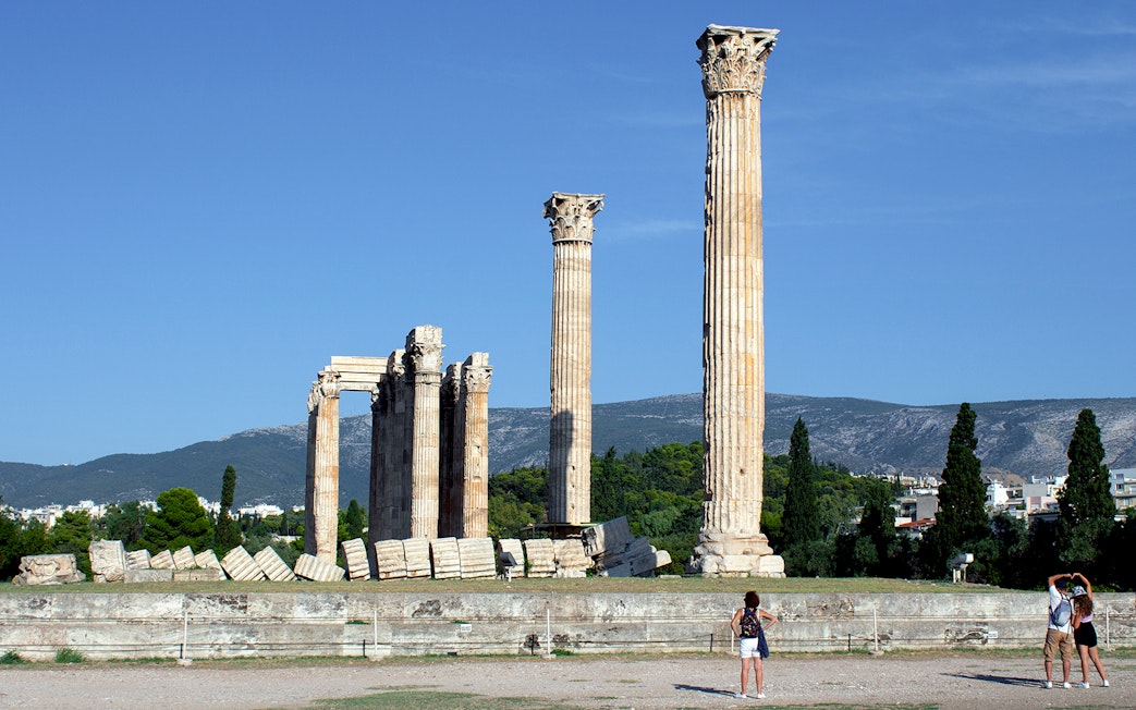 Ancient Temple of Olympian Zeus ruins in Athens with tourists exploring.
