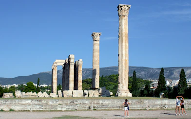 Ancient Temple of Olympian Zeus ruins in Athens with tourists exploring.