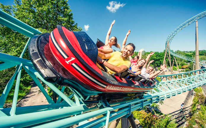Roller coaster ride with excited visitors at Nigloland, France.