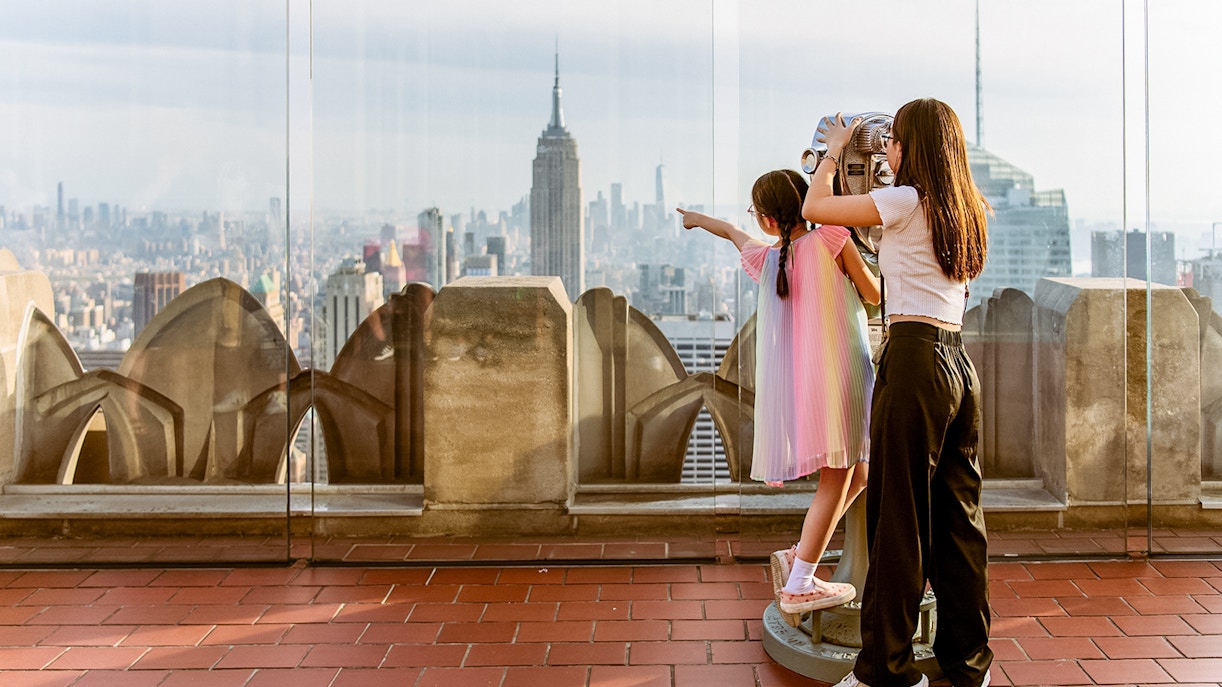 Children using binoculars at Top of the Rock, Rockefeller Center, New York City skyline view.