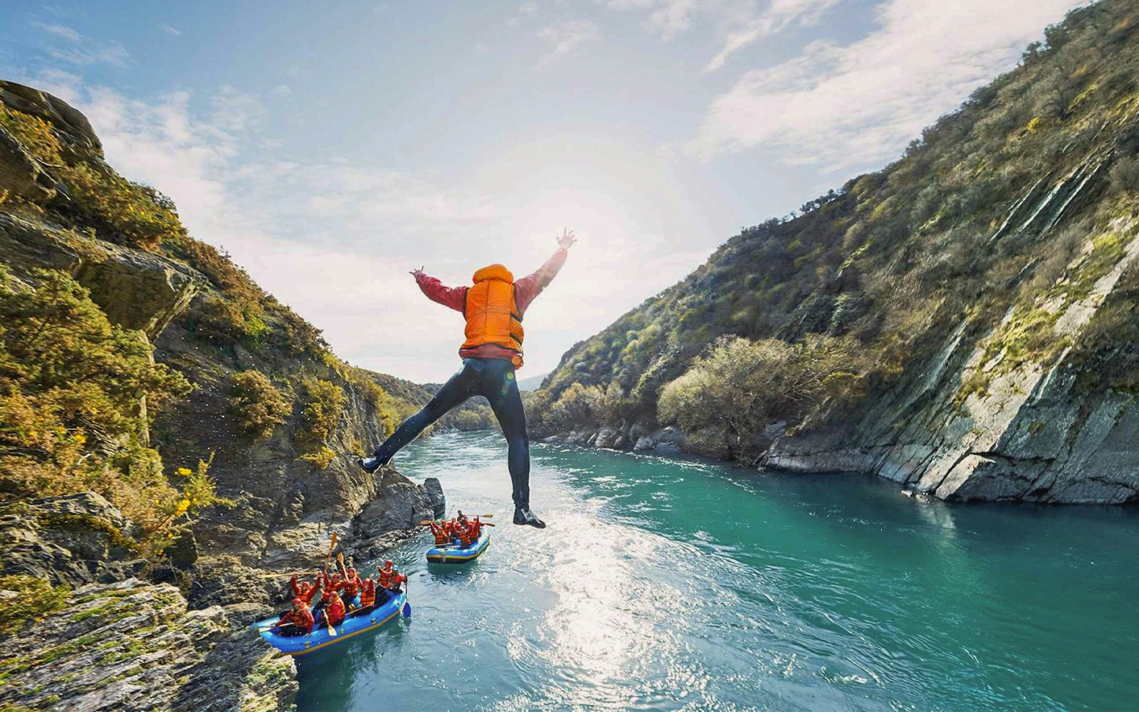 Tourist jumping into Kawarau River during white water rafting adventure.