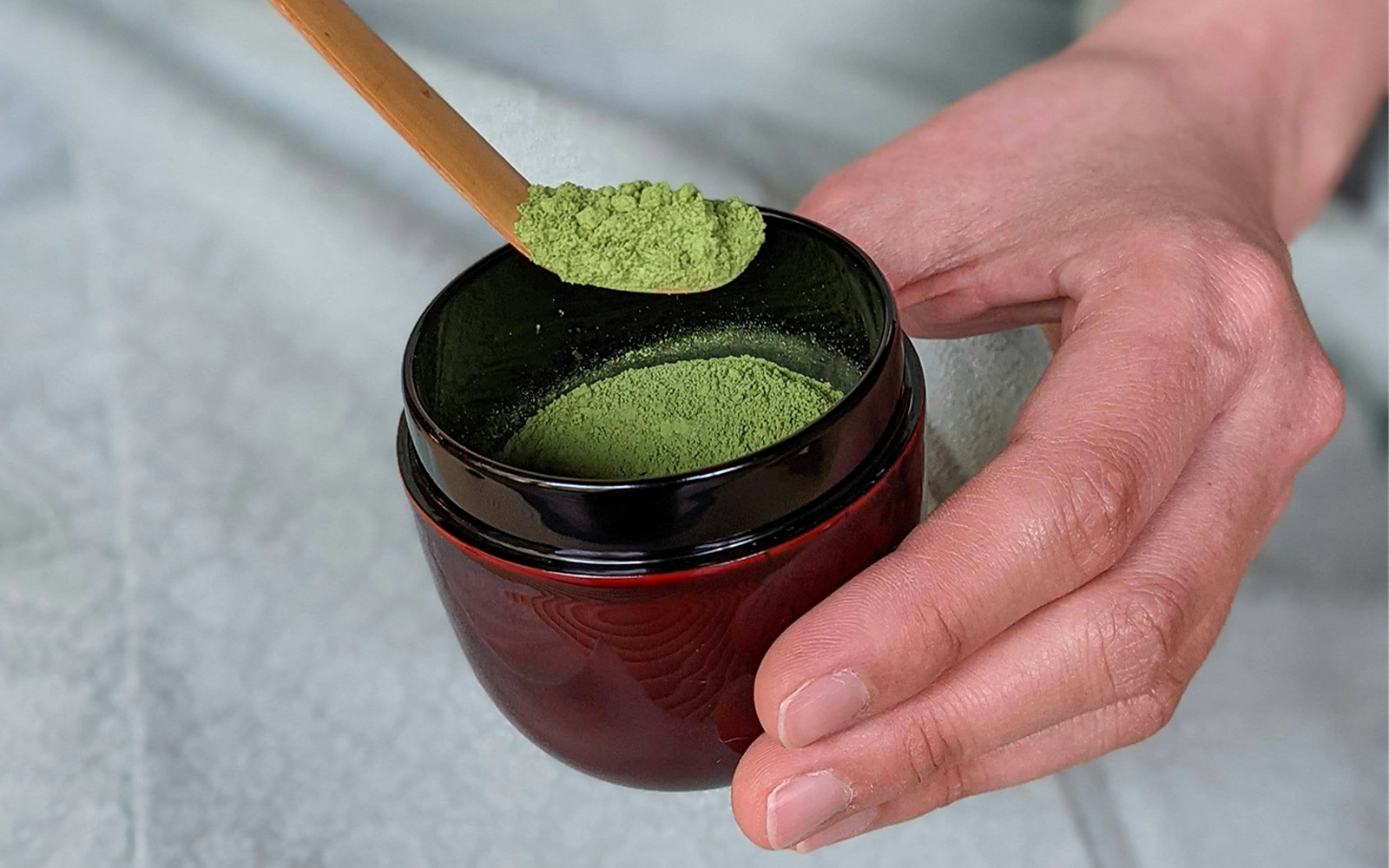 Matcha powder in a red bowl with a bamboo scoop, Flower Teahouse Kyoto ceremony.