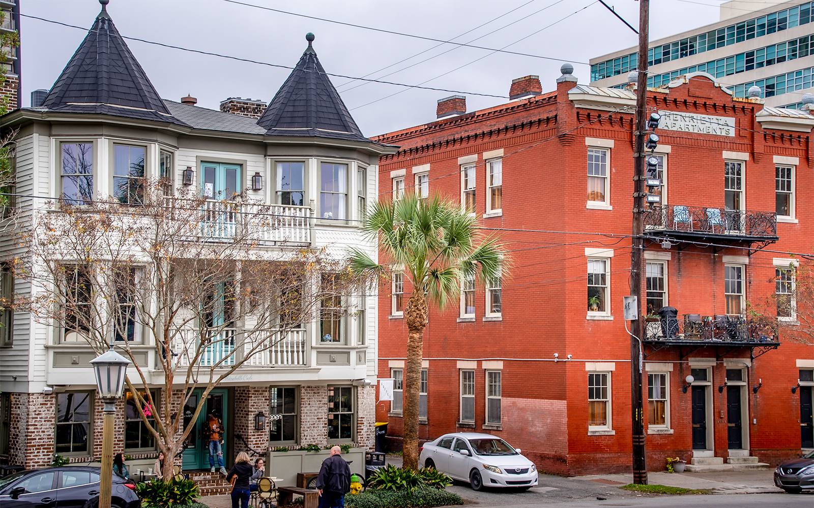 Des touristes profitent d'un tour Hop-On Hop-Off de Savannah par une journée ensoleillée, en passant devant des bâtiments historiques et des parcs verdoyants.