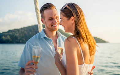 Couple enjoying champagne on Heraklion catamaran cruise with scenic ocean view.