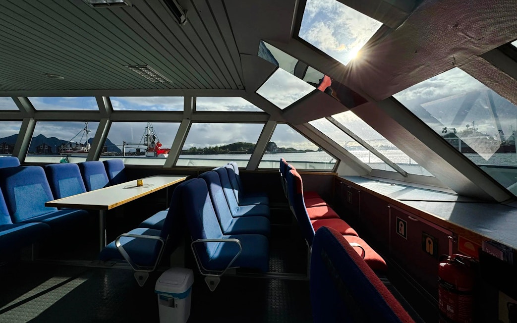 Interior view of Trollfjord cruise ship with seating and large windows, Lofoten.