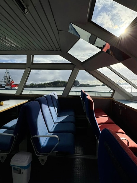 Interior view of Trollfjord cruise ship with seating and large windows, Lofoten.