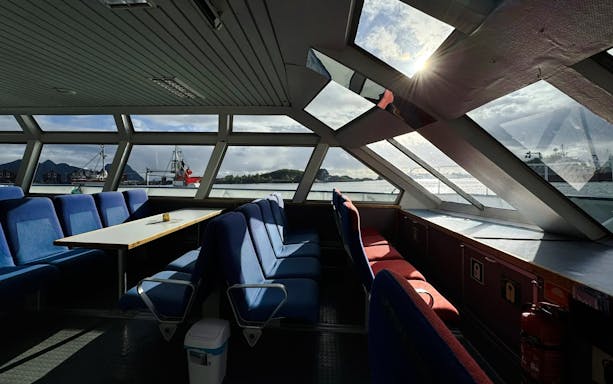 Interior view of Trollfjord cruise ship with seating and large windows, Lofoten.