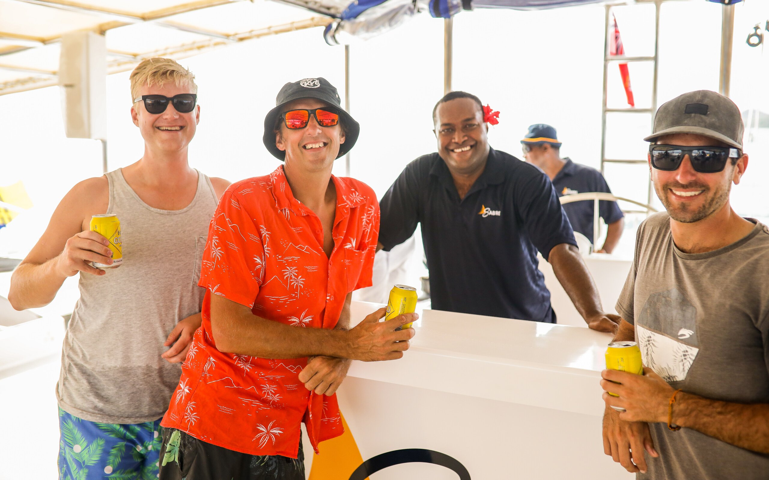Guests enjoying drinks on the Sabre Sunset Cruise with crew members.