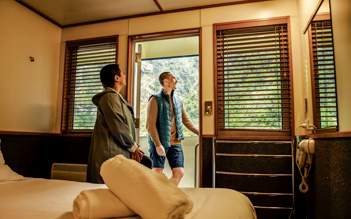 Couple enjoying cabin view on Doubtful Sound cruise.