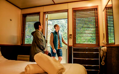 Couple enjoying cabin view on Doubtful Sound cruise.