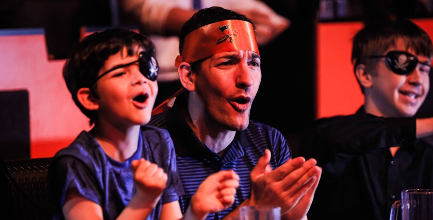 Guests cheering at Pirates Dinner Adventure Show.