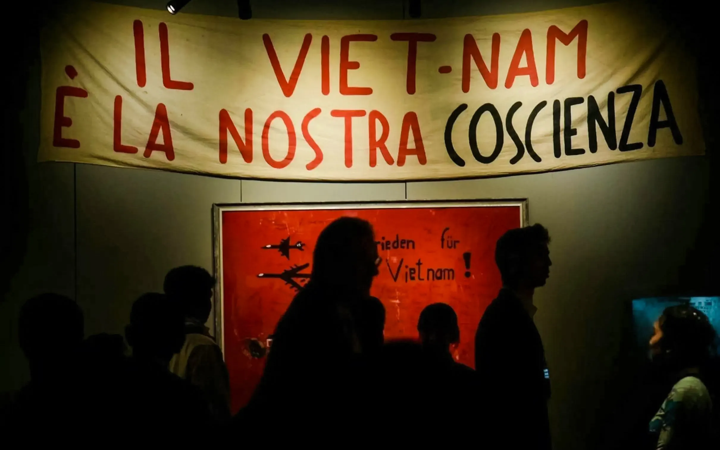 Banner with "Il Viet-Nam è la nostra coscienza" in Italian, people silhouetted below.